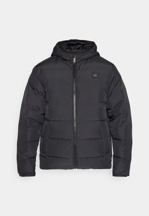 Giubbotto piumino nero isolato con cappuccio, dotato di una cerniera frontale e due tasche laterali, decorato con una piccola patch con il logo sul petto.