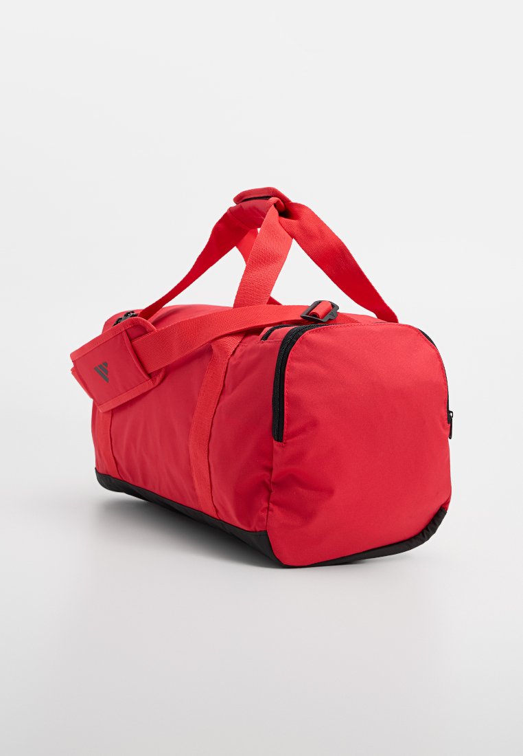 Bolsa de deporte roja con base negra, hecha de tela duradera. Cuenta con dos asas y una correa de hombro desmontable; cierre con cremallera y detalles.