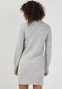 Robe pull en tricot gris avec un col rond, des manches longues et un ourlet côtelé. Texture douce avec un motif chiné subtil.