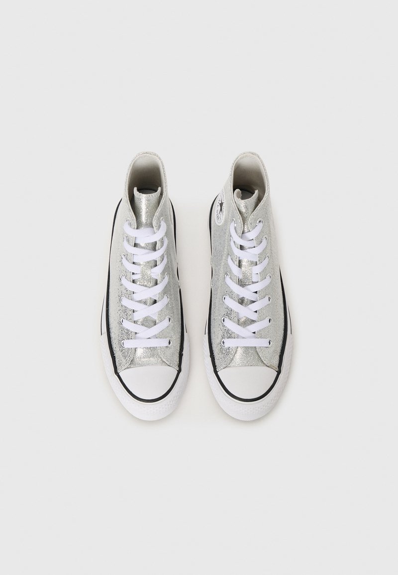 Zapatillas altas hechas de material metálico plateado, con cordones blancos, acentos negros y un diseño de punta redonda con suela de goma.