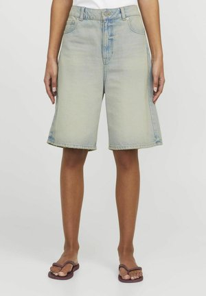 Bermudas en denim bleu clair avec une taille mi-haute, coupe ample et ourlet effiloché. Dispose de poches avant traditionnelles et d'un léger dégradé.