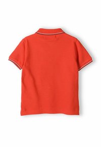 Piros póló, lélegző anyagból készült. Ribbed gallérral és kontrasztos csíkokkal, rövid ujjú kialakítással rendelkezik. Sima felület, hétköznapi dizájn.