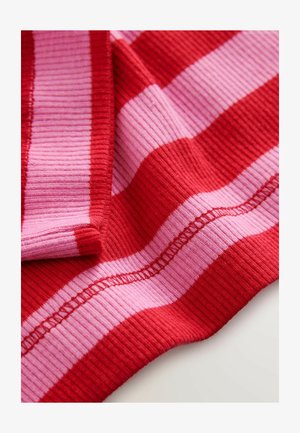 Piros és rózsaszín bordázott szövet vízszintes csíkokkal; puha textúrájú, és a szélek mentén látható varrási részletekkel.