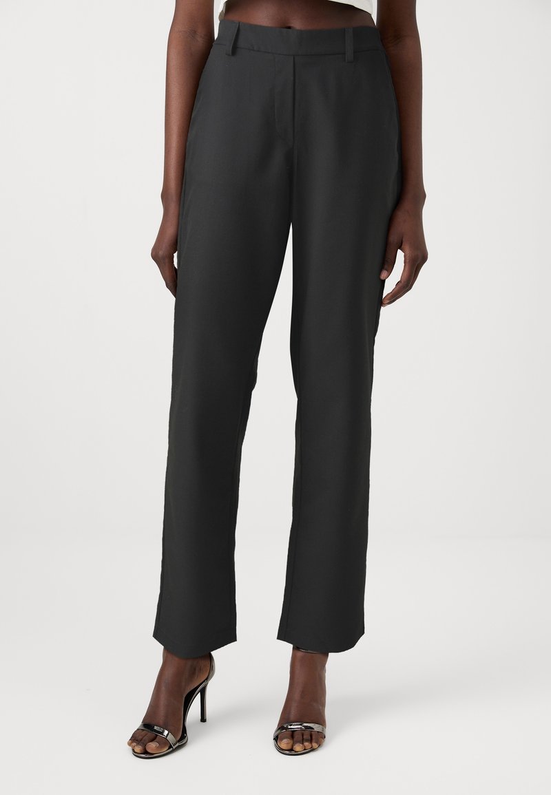 Černé široké kalhoty z hladkého materiálu, s plochým předním dílem a poutky na opasek. Slušné k černým vysokým podpatkům.