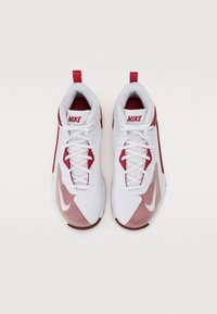 Chaussures de sport blanches avec des accents rouges, dotées d'une tige en maille, d'un col rembourré et de lacets blancs. Logo Nike visible sur la languette et sur le côté.