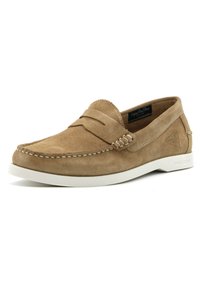 Scarpa slip-on in suede beige con design mocassino cucito, suola in gomma bianca e una fascia decorativa in pelle sulla parte anteriore.