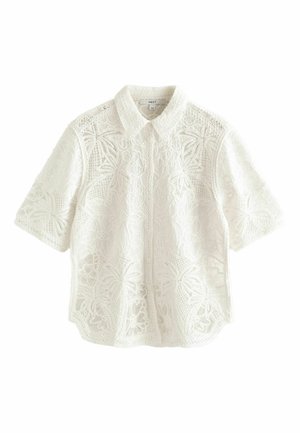 White short-sleeve shirt with intricate lace patterns, featuring a button-up collar and a loose fit, crafted from a lightweight textile.