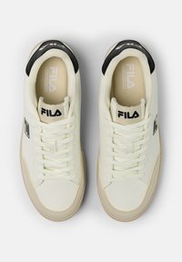 Vita sneakers med en slät läderutsida, svart hälaccent och snörningsdesign. Har Fila-logotyp på sidan och stoppad krage.