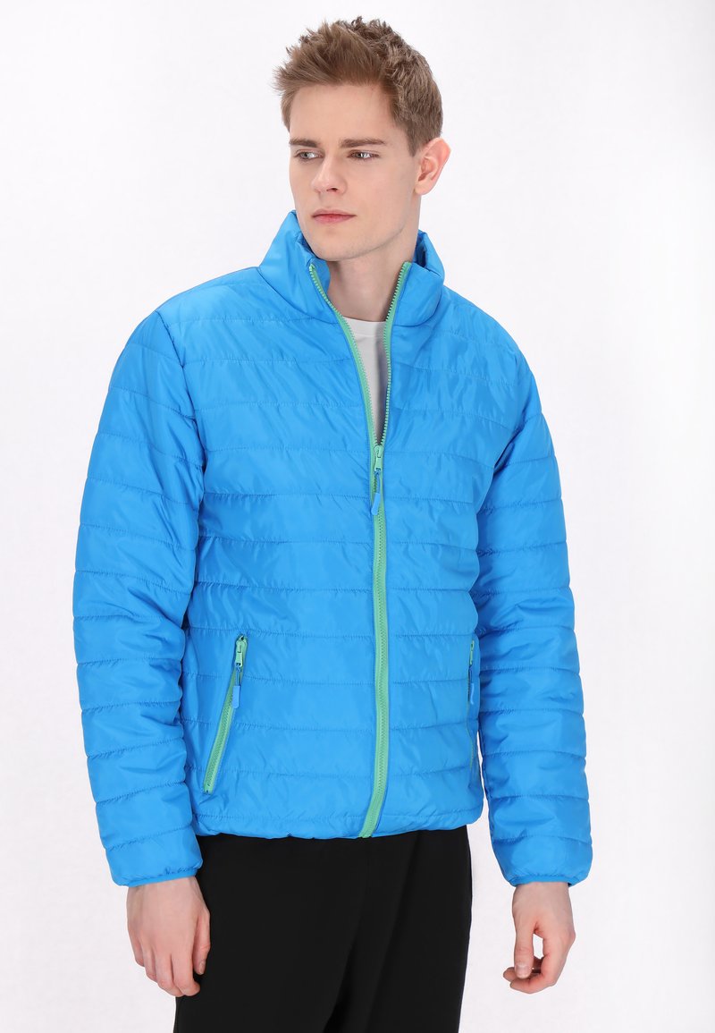 Blå pufferjakke med høj krave, udstyret med en grøn lynlås og sidelommer. Stoffet har en quiltet struktur med vandret syninger.