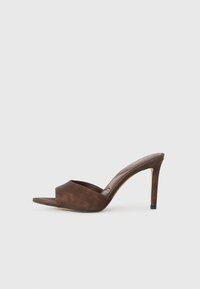 Mule marron à talon haut avec bout ouvert et talon stilettos fin, présenté de profil sur un fond blanc uni.