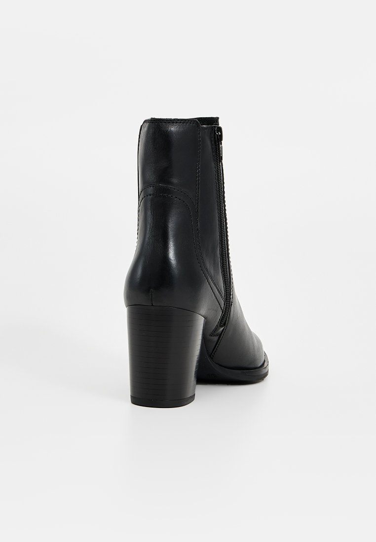 Czarne skórzane botki do kostki z piętą blokową i bocznym zamkiem, przedstawione z tyłu na białym tle.