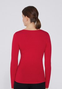 Rode langemouwen fitted top met een zachte textuur en een brede halslijn, met een naadloos ontwerp en een gladde finish aan de onderkant.