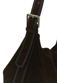 Anse de sac à main en daim marron foncé avec boucle argentée et boucle en daim assortie sur fond uni.