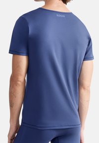 Dunkelblauses T-Shirt mit kurzen Ärmeln, aus weichem Stoff gefertigt, verfügt über einen Rundhalsausschnitt und ein Logo auf der Rückseite. Glatte Textur mit minimalen Nähdetails.