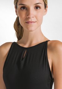 Prenda negra sin mangas con un detalle de escote en forma de llave, textura suave y un diseño ajustado. Estilo minimalista, sin patrones ni adornos.