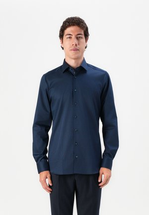 Mørkeblå skjorte med knapper laget av glatt stoff. Har krage, lange ermer og en tettsittende design med matchende knapper.