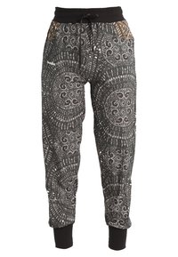 Czarne spodnie dresowe z geometrycznym białym wzorem, elastycznym pasem, sznurkiem i zwężanymi mankietami. Miękki materiał z teksturowanym wzorem.