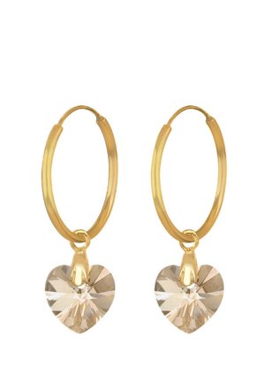 Boucles d'oreilles en or avec un pendentif en cristal transparent en forme de cœur, présentant une finition polie et une texture lisse.