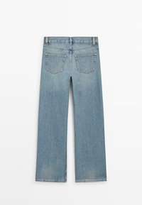Jean en denim bleu clair avec jambes droites, deux poches arrière, passants pour ceinture et coutures visibles sur un fond blanc uni.