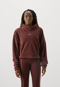 Kroppte Fleece-Sweatshirt in Weinrot mit hohem Kragen, Kordelzug und weißem Logo. Kombiniert mit passenden Weinroten Leggings mit weißen Seitenstreifen.