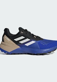 Baskets de course noires et bleues avec une tige en maille, trois bandes blanches, accents beiges et une semelle texturée. Adaptées aux conditions humides.
