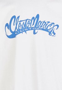 White cotton T-shirt featuring a prominent blue graphic text that reads "ClestoManiac CUSTOMS" in a stylized font.