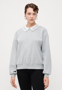 Grauer Sweatshirt mit einem weißen, gestickten Kragen sowie gerippten Bündchen und Saum, mit einem lässigen Schnitt und weicher Textur.