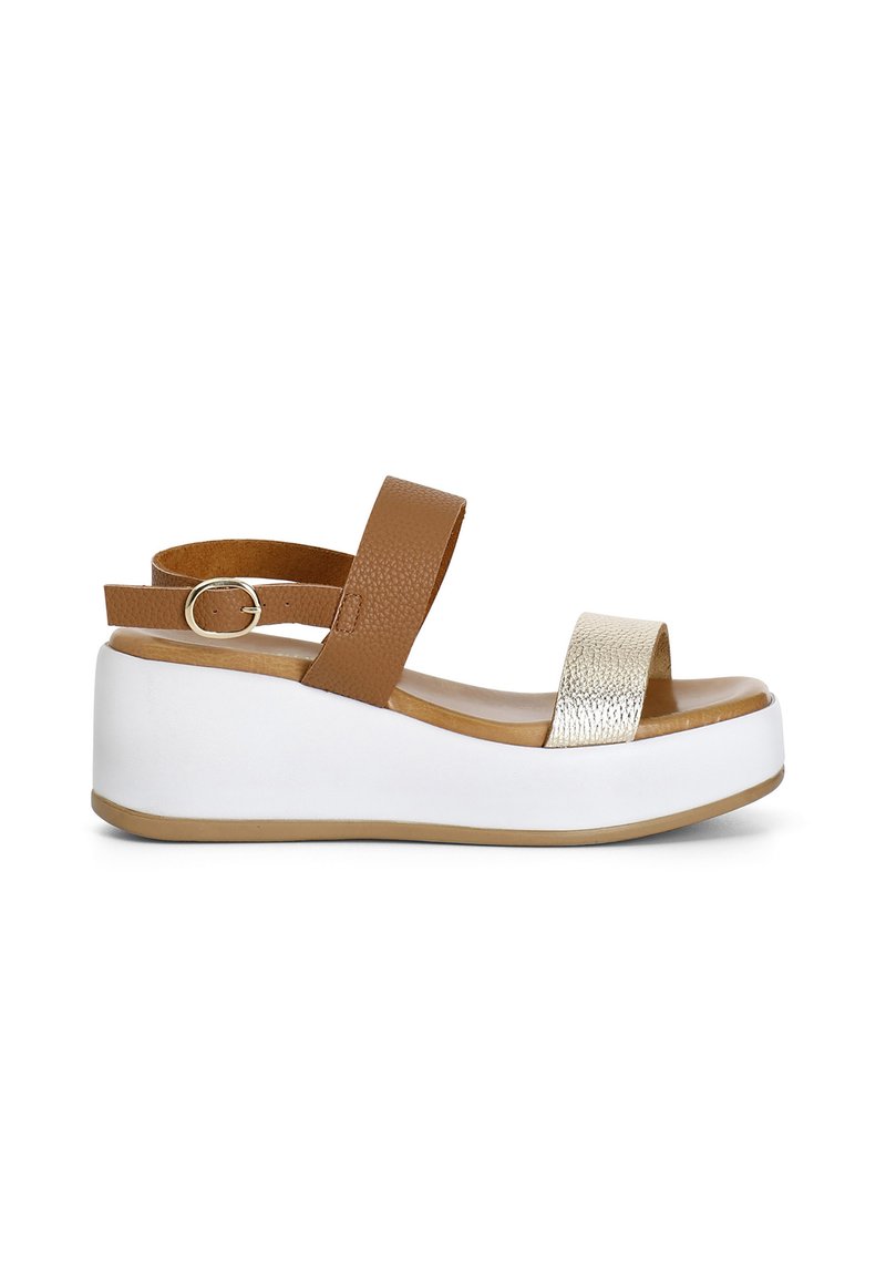 Platformové sandály s hnědým koženým řemínkem kolem kotníku, metalickým stříbrným páskem na prstech a bílou wedge podrážkou s texturovanou hnědou stélkou.