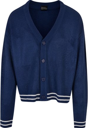 Meriharmaa ribbet cardigan V-päällä, jossa on viisi nappia ja valkoiset raidat hihansuissa ja helmoissa. Pehmeä rakenne ja tiukka muotoilu.