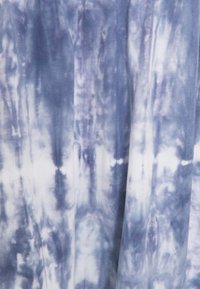 Tkanina tie-dye w odcieniach niebieskiego i białego, o gładkiej teksturze i płynnych wzorach tworzących efekt marmuru.