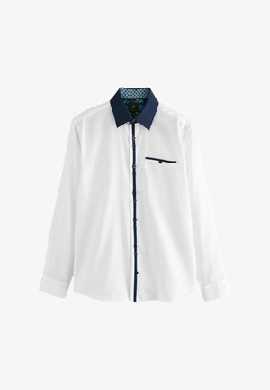 Valge pikkade varrukatega särk tumesinise tekstuuriga kraega ja täpilise sisemise voodriga. Omab tumesinist tasku aktsenti ja tumedaid nuppe.