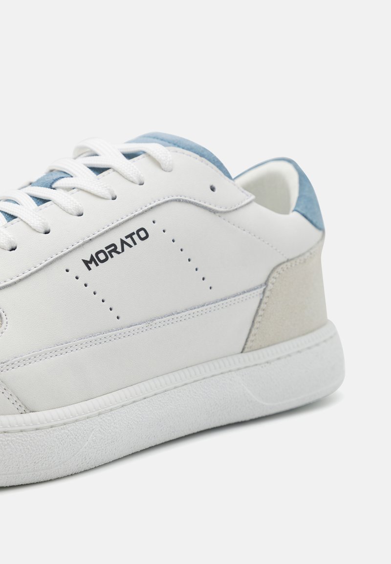 Sneaker in pelle bianca con accenti in suede azzurro chiaro e beige, suola in gomma testurizzata e dettagli perforati. Logo "Morato" visibile di lato.
