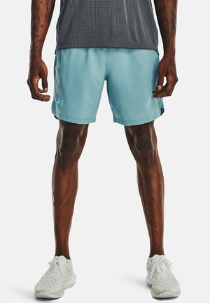 Shorts de sport bleu clair avec une texture lisse, associés à un t-shirt gris foncé à évacuation de l'humidité. Chaussures de sport blanches avec un design en mesh.