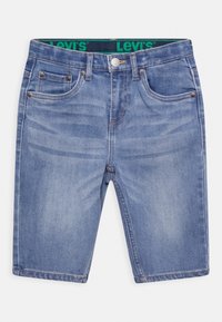 Světlemodré džíny s rovný střih, pět kapsami, kovovými knoflíky a zeleným pasem Levi's. Jemně vybledlý vzhled.