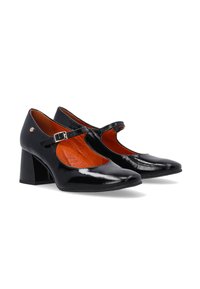 Black patent leather Mary Jane shoes with a square toe, curved cutouts, and a buckle strap. Features a low block heel and orange insoles.