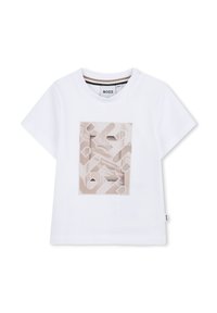 T-shirt bianco a maniche corte con un design geometrico beige al centro, caratterizzato da varie forme e un dettaglio circolare. Etichetta sul lato.