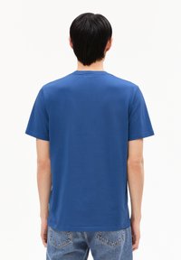 T-shirt in cotone blu con collo a giro, maniche corte e vestibilità rilassata. Dettagli di cuciture visibili e design senza cuciture sul retro.