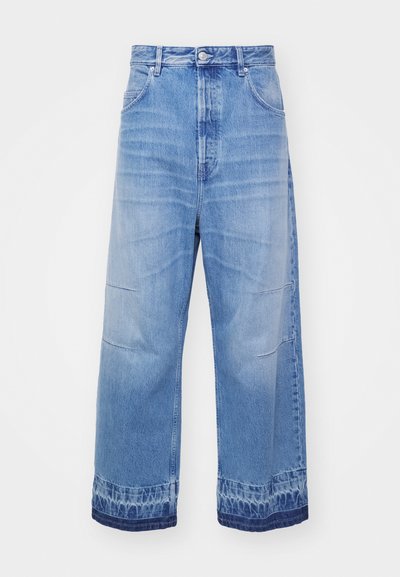 Jeans en denim bleu clair avec un design à jambes larges, présentant des détails de délavage, deux poches avant et un ourlet à motifs.