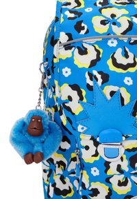Blue backpack with a floral pattern in black, white, and yellow. Features a blue zipper with a star accent and a blue gorilla charm.