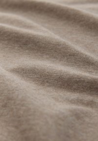 Hellbrauner Baumwollstoff mit weicher, glatter Textur und leichtem Stretch, der subtile Farbvariationen und ein mattes Finish aufweist.