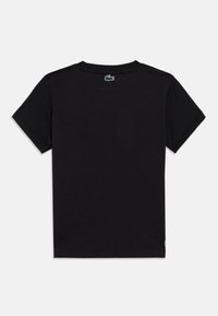 Μαύρο μπλουζάκι με στρογγυλή λαιμόκοψη, κοντά μανίκια και μικρό πράσινο λογότυπο κροκοδείλου στο πίσω μέρος του λαιμού. Λείο βαμβακερό ύφασμα.