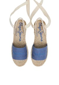 Sinine kangast espadrillid, millel on kootud jute tallad, tikitud brändingu ja kitsaste beežide rihmadega. Sile materjal, ümar kuju.