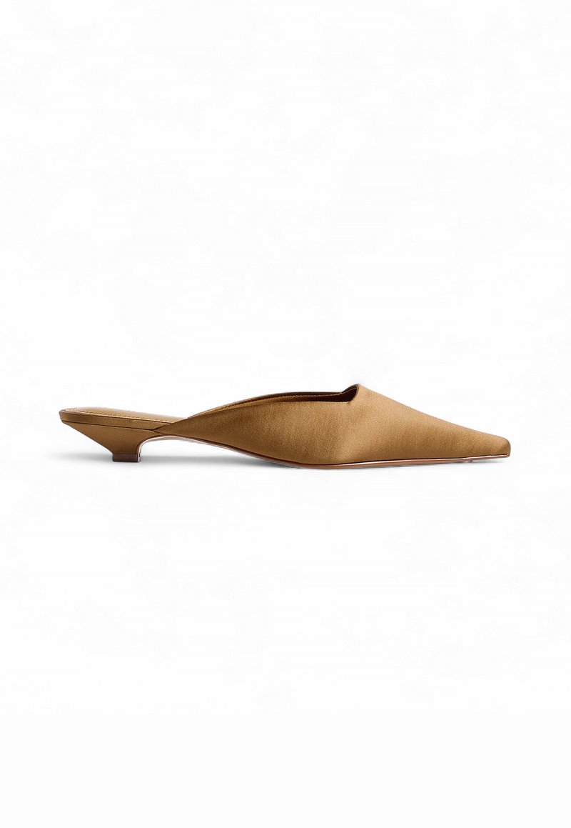 Mule à bout pointu en daim couleur tan, avec un petit talon et une silhouette élégante. Présente une texture lisse et un design ouvert à l'arrière.