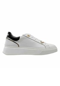Zapatilla de cuero blanca con acento en el talón negro, ojales dorados y suela de goma blanca texturizada. Presenta un diseño aerodinámico para mayor versatilidad.