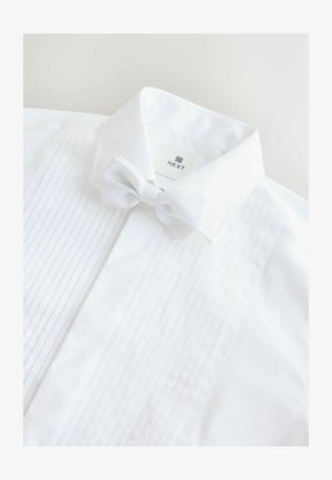 Weißes Hemd mit gefältelter Vorderseite, umgeschlagenem Kragen und einer passenden weißen Fliege mit strukturiertem Punktmuster. Markenetikett sichtbar.