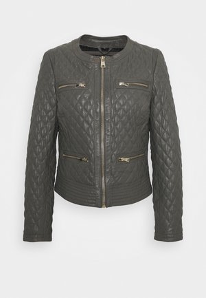 Chaqueta de cuero acolchado gris con cuello redondo, cierre delantero con cremallera, dos bolsillos en el pecho y una silueta ajustada. Acentos en hardware dorado.