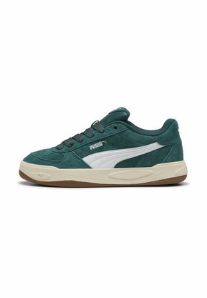 Πράσινο σουέντ αθλητικό παπούτσι Puma με λευκή πλαϊνή ρίγα, μπεζ μεσαία σόλα, καφέ εξωτερική σόλα και μαύρα κορδόνια, εμφανίζεται σε πλευρικό προφίλ σε λευκό φόντο.