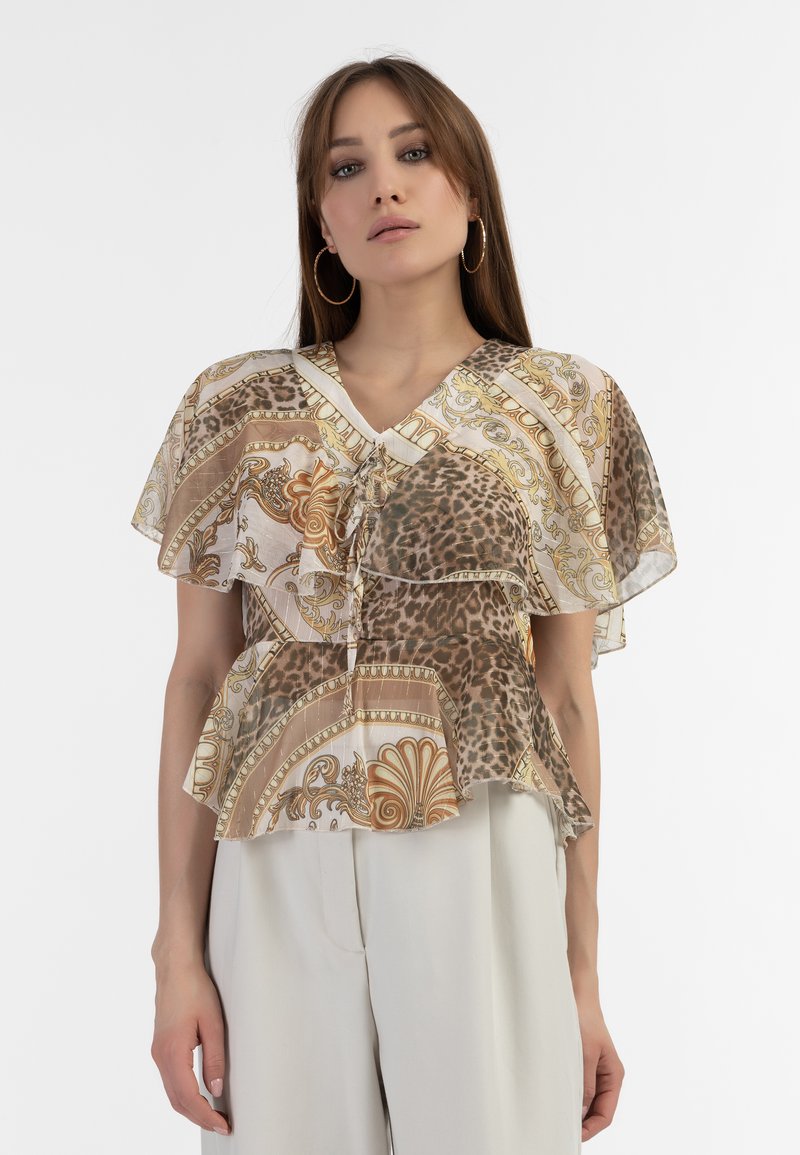 Trykt peplum top med lagdelte flæser, præget af dyreprint og udsmykkede gyldne mønstre i brune og kremfarvede nuancer. V-halsdesign.