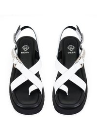 Zwart-witte sandalen met een kruisbandontwerp, synthetisch materiaal, verstelbare slingback, gevoerde binnenzool en details in zilver.