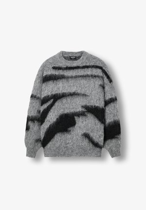 Pelēks adīts džemperis ar pūkainu faktūru, masīvām melnām abstraktām svītrām, apaļu kakla izgriezumu un ribotām piedurknēm un apakšmalu.